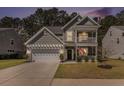 Charming two-story home with a double porch, a manicured lawn, and an attached two-car garage at 165 Vango Dr, Goose Creek, SC 29445