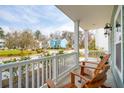 Relaxing front porch view with white railings and comfortable wooden chairs at 1651 Valley Oak Rd, Johns Island, SC 29455