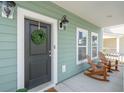 Inviting front porch with rocking chairs, a wreath, and charming exterior lighting at 1651 Valley Oak Rd, Johns Island, SC 29455