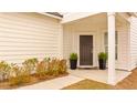 A well-decorated front porch featuring potted plants, manicured bushes, and a stylish welcome mat at the entrance at 178 Garden Gate Way, Summerville, SC 29486