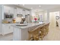 Bright kitchen boasts white cabinets, granite countertops, stainless steel appliances, and counter seating at 178 Garden Gate Way, Summerville, SC 29486