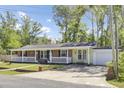 Attractive home with a brick and siding exterior, a lovely porch, and mature trees in the front yard at 1861 Jaywood Cir, Charleston, SC 29407