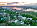 An aerial view of a beautiful home with pool surrounded by trees near a bay and a scenic bridge at 204 E Huron Ave, Folly Beach, SC 29439
