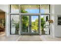 Bright foyer with tall windows and glass doors offering views of greenery and natural light at 204 E Huron Ave, Folly Beach, SC 29439
