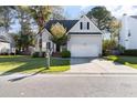 Inviting two-story home with a manicured lawn and a two-car garage, set against a backdrop of mature trees at 2050 S Smokerise Way, Mount Pleasant, SC 29466