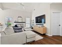 Open-concept living room with a large sofa, wood floors, and a fireplace, offering a cozy and modern space at 2050 S Smokerise Way, Mount Pleasant, SC 29466
