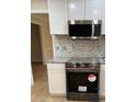 Modern kitchen featuring stainless steel appliances, white cabinets, and a stylish backsplash at 208 Woodland Dr, Summerville, SC 29485