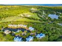 Beautiful aerial view of property featuring a lake, horse pasture, landscaping, and blue skies at 2472 Racquet Club Dr, Seabrook Island, SC 29455