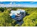 Aerial view of the condo building featuring multiple balconies, a blue metal roof, and lush surrounding trees at 2472 Racquet Club Dr, Seabrook Island, SC 29455