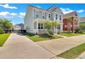 View of the home's exterior with a long driveway leading to a detached garage and fenced yard at 2842 Rutherford Way, Charleston, SC 29414