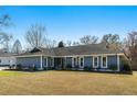 Charming single-story home featuring a well-manicured lawn and lush landscaping under a blue sky at 2899 Doncaster Dr, Charleston, SC 29414