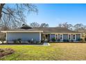 Charming single-story home featuring a well-manicured lawn and lush landscaping at 2899 Doncaster Dr, Charleston, SC 29414