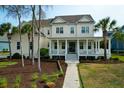 Beautiful two-story home boasts a classic design with a welcoming front porch, landscaped yard, and mature trees at 2961 Yachtsman Dr, Mount Pleasant, SC 29466