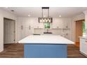 Bright kitchen featuring a blue island, white cabinets, and modern lighting at 3166 Edenvale Rd, Johns Island, SC 29455
