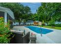 Backyard pool surrounded by lush greenery, featuring patio furniture and storage sheds at 3308 Island Estates Dr, Johns Island, SC 29455