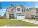 Inviting two-story home with a two-car garage, complemented by lush greenery and a manicured lawn at 343 Iveson Rd, Summerville, SC 29486