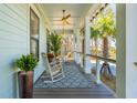 Inviting porch with rocking chairs, stylish rug, and views of tropical foliage at 3894 Sawyers Island Dr, Mount Pleasant, SC 29466
