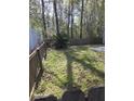 Fenced backyard featuring green grass, surrounding mature trees, and an open space at 399 Stefan Dr, Charleston, SC 29412