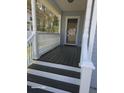 Inviting front porch featuring classic white railings, decorative columns, and a dark wood-stained floor at 399 Stefan Dr, Charleston, SC 29412