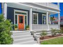 Charming home showcasing a colorful door, white columns, and well-manicured landscaping at 4 Kenilworth Ave, Charleston, SC 29403