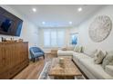 Comfortable living area with a cozy sectional, wood floors, natural light, and a classic wood cabinet at 400 Bucksley Ln # 103, Charleston, SC 29492