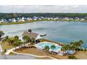 Community pool with lake view, palm trees and ample seating, perfect for relaxation and social gatherings at 4021 Brown Trout Dr, Johns Island, SC 29455