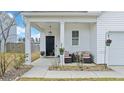 Inviting front porch with comfortable seating, decorative plants, and a stylish black front door at 429 Pender Woods Dr, Summerville, SC 29486
