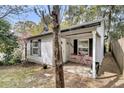 Charming home exterior with a cozy front porch, a small table with two red chairs and blooming plants at 4445 Old Park Rd, North Charleston, SC 29405