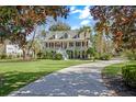 Beautifully landscaped property featuring a classic two-story home with mature trees and a long driveway at 5010 Timber Race Crse, Hollywood, SC 29449