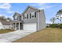 Charming two-story home featuring gray siding, black shutters and a two-car garage at 5115 Cranesbill Way, Johns Island, SC 29455