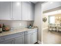 Butler's pantry featuring gray cabinets, granite countertops, and a view into the dining room at 523 Verdi Dr, Summerville, SC 29486