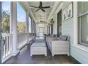 Inviting front porch with comfortable seating, ceiling fans, and serene views at 740 Stucco Ln, Mount Pleasant, SC 29464