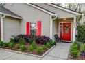 Inviting home exterior with red shutters, a decorative door, and landscaped garden, offering charm and curb appeal at 8095 Old London Rd, North Charleston, SC 29406