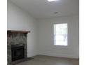Cozy living room with a stone fireplace, bright white walls, and a large window at 8311 Whitehaven Dr, North Charleston, SC 29420