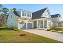 Charming exterior elevation with a two-car garage, well-maintained lawn, and covered front porch at 1028 Harriman Ln, Charleston, SC 29492