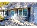 Close-up view of the inviting front porch with a 'Welcome' sign and a rocking chair at 115 Tennyson Way, Summerville, SC 29486