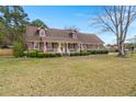 Traditional-style home with well-maintained lawn and shrubs, complemented by American flags at 117 Hartin Blvd, Summerville, SC 29486