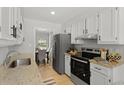 Bright kitchen featuring white cabinets, stainless steel appliances, granite countertops and a view of the dining area at 121 Milton Dr, Goose Creek, SC 29445