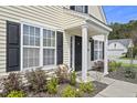 Home entrance featuring a dark front door, white columns, and landscaping at 1249 Shadow Mist Ln, Charleston, SC 29492