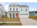 Charming two-story home with a bright red door and dormer windows at 1420 Homecoming Blvd, Ravenel, SC 29470