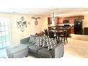 An open-concept living area seamlessly connects to the kitchen, complete with a dark gray sectional sofa and dark brown cabinetry at 148 Saint Charles Way, Goose Creek, SC 29445