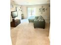 Comfortable living room with neutral carpet, a dark gray sectional sofa, and sliding glass doors leading to the backyard at 148 Saint Charles Way, Goose Creek, SC 29445