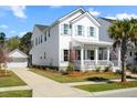 Beautiful two-story white home with a charming front porch, manicured lawn and a detached garage at 1772 Agate Bay Dr, Mount Pleasant, SC 29466
