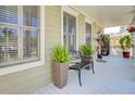 Relaxing covered front porch with comfortable seating and potted plants, creating a welcoming atmosphere at 185 5Th Ave, Mount Pleasant, SC 29464