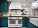 Up close view of professional range with butcher block countertops and herringbone backsplash at 2014 Ion Ave, Sullivans Island, SC 29482