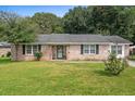 Quaint brick home with a green lawn, decorative shutters, and a welcoming entrance at 208 James St, Summerville, SC 29483