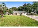 Traditional brick home with a well-maintained lawn, covered carport, and mature trees at 208 James St, Summerville, SC 29483