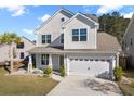 Charming two-story home showcasing a well-manicured lawn and attached two-car garage at 211 Saxony Loop, Summerville, SC 29486