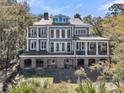 Expansive rear exterior featuring a large deck, covered porch, and lush surroundings at 2292 Beckenham Dr, Mount Pleasant, SC 29466