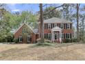 Traditional two-story brick house with symmetrical design, black shutters, and a covered entrance, set on a large lot at 235 Scalybark Rd, Summerville, SC 29485